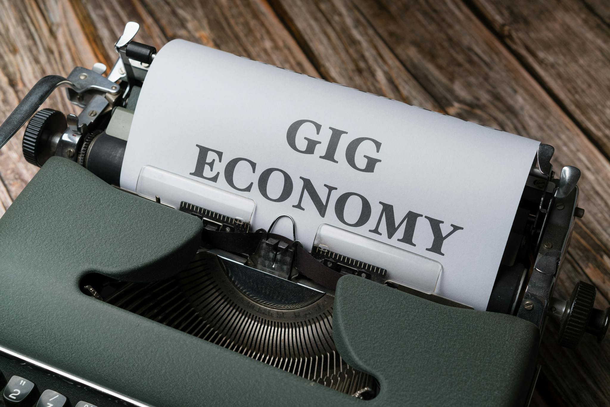 Close-up of a vintage typewriter with 'Gig Economy' typed on paper, showcasing modern work trends.